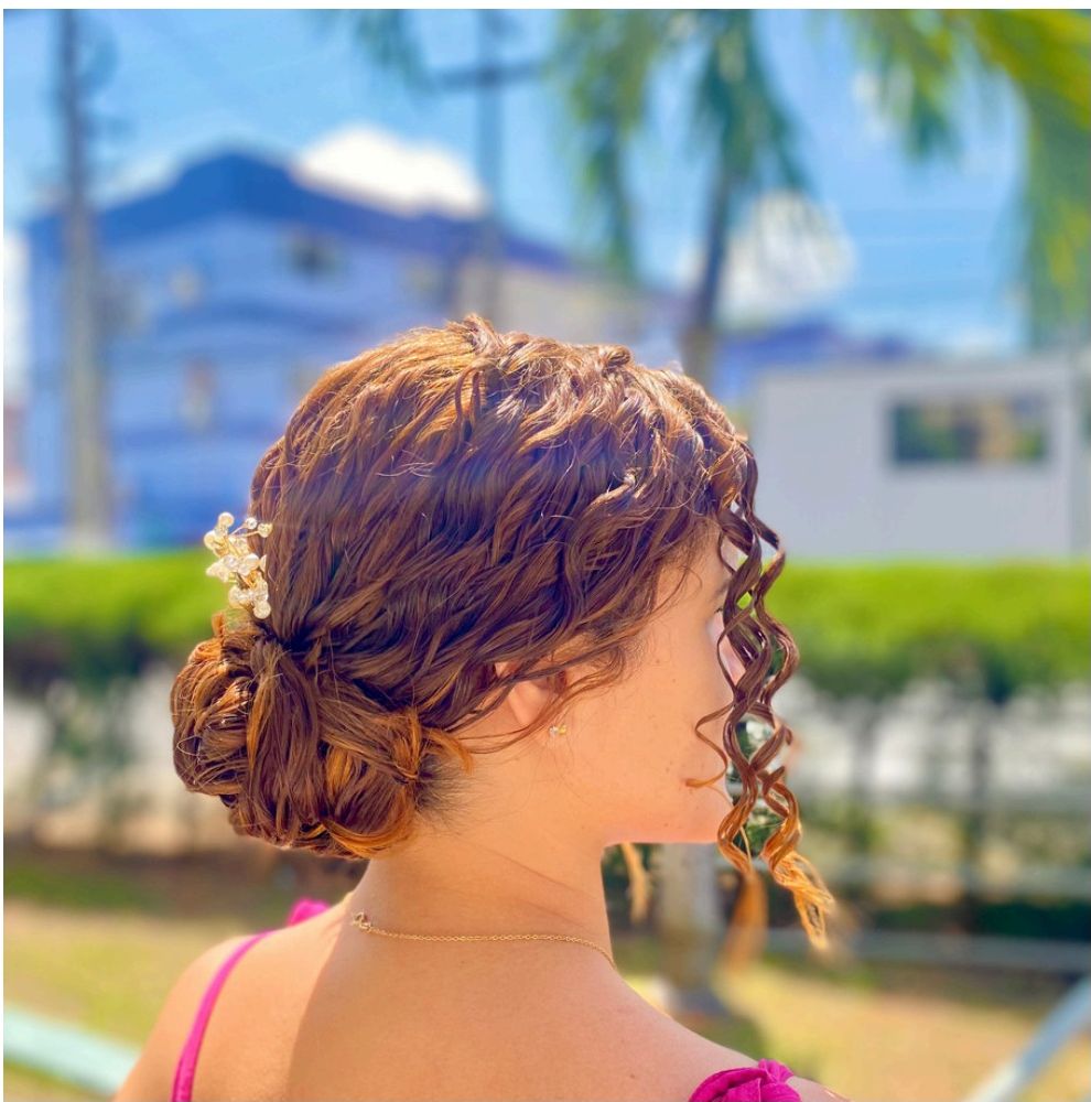 Penteado semipreso com acessório de pérolas em cabelo cacheado