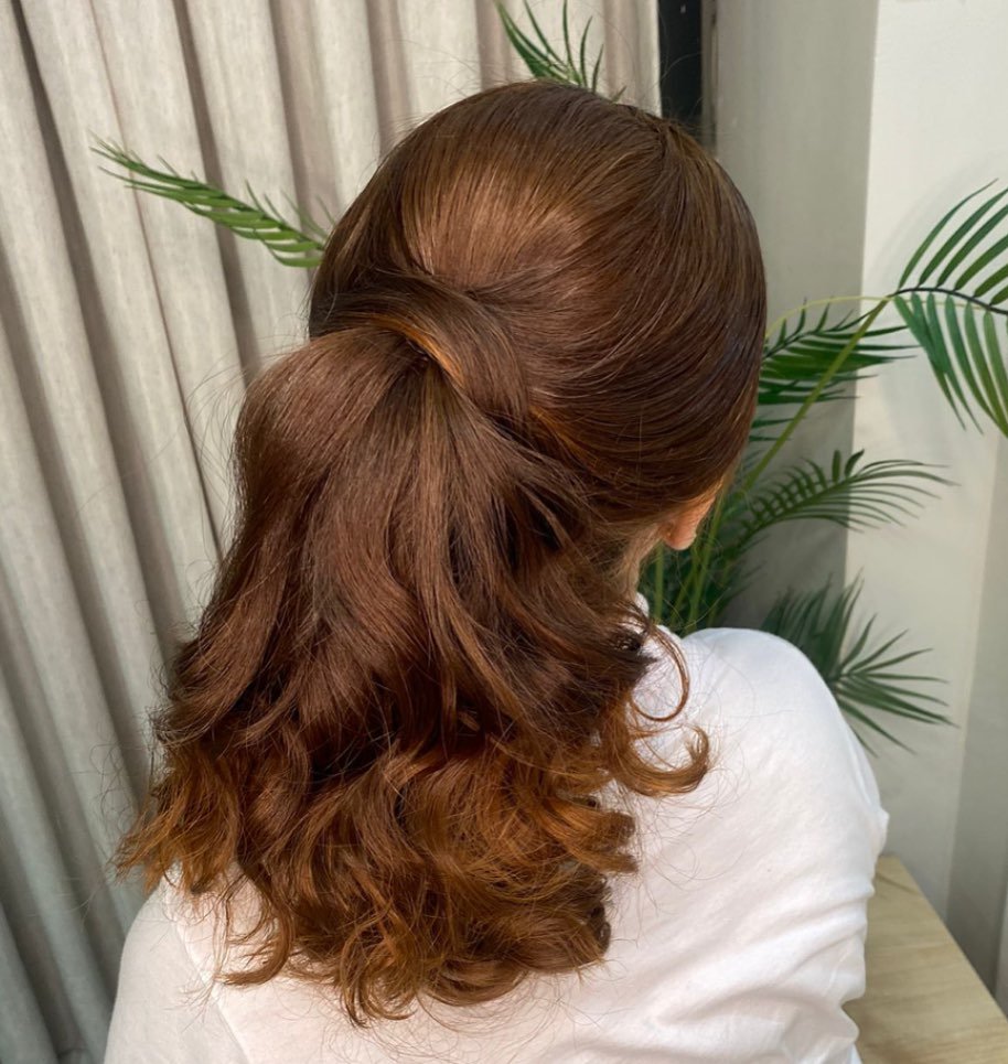 Rabo de cavalo baixo em cabelo acobreado com pontas onduladas
