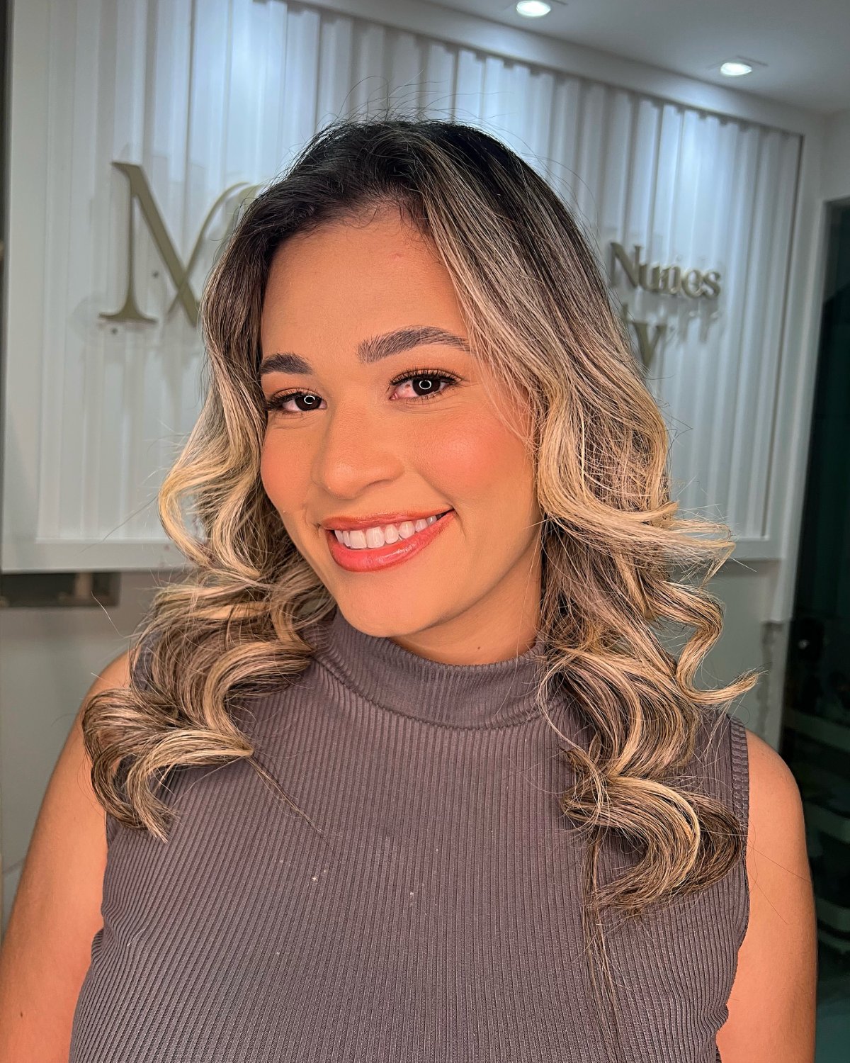 Ondas médias com mechas loiras e maquiagem social